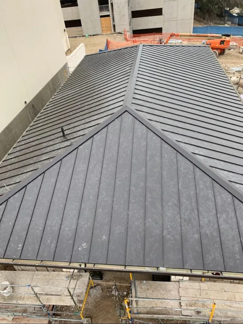 Commercial metal roof construction with crane equipment in Streator