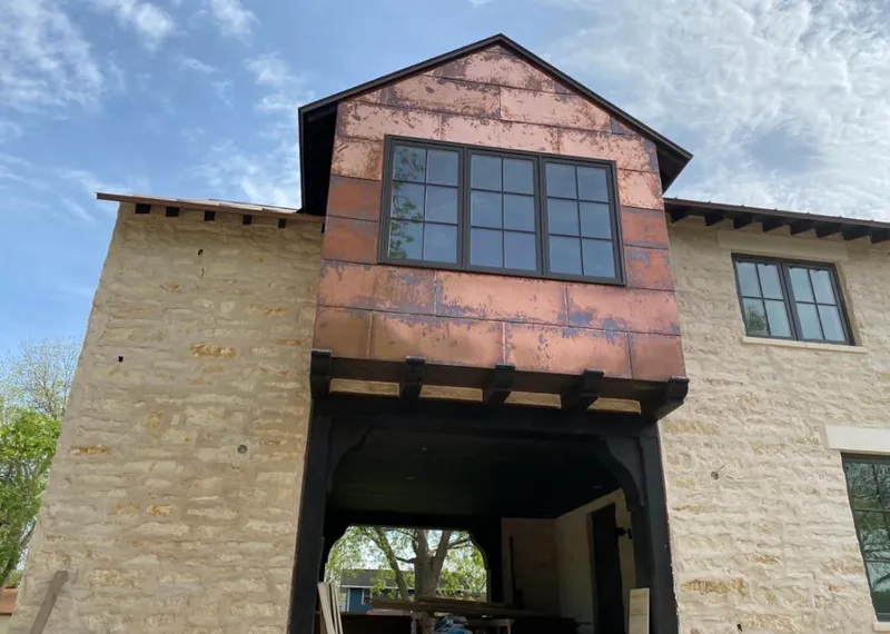 Copper metal panel facade on a stone building for Roof Repair in Streator